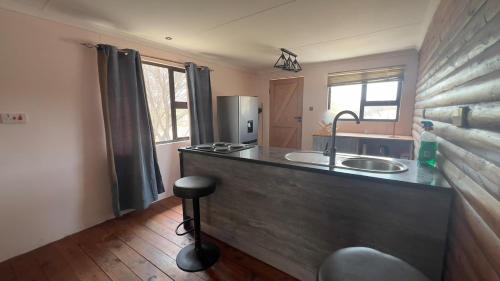 a kitchen with a counter with a sink and a stove at Maun HideOut in Maun Airport