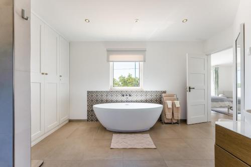 e bagno con finestra e vasca. di Villa Benjamin - Vale do Lobo a Vale do Lobo