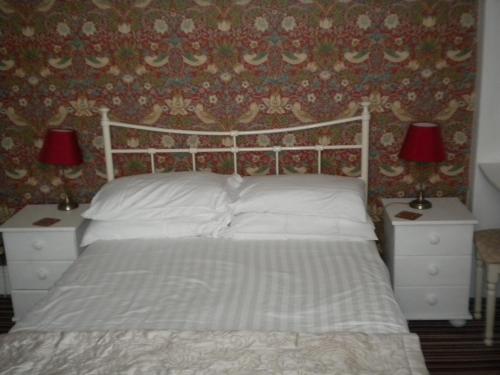 una camera da letto con un letto con due comodini e due lampade di Morlea Guest House a Llandudno