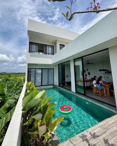a house with a swimming pool with a frisbee in it at Cemagi Beach Hostel by Verdana Pool & Events in Cemagi