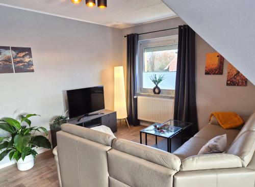 a living room with a couch and a tv at Ferienwohnung Neckel Hohnstorf in Hohnstorf