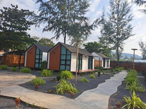 Una hilera de cabañas con plantas en un patio. en Seashell Family-555普吉岛木屋走几步到邦涛海滩看日落周边餐饮方便, en Bang Tao Beach