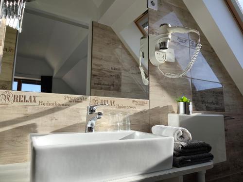 um banheiro com pia branca e espelho em Darázshegyi Panzió gluténmentes félpanzióval is em Mátraszentimre