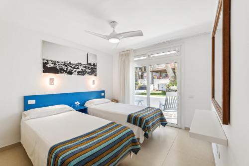 una camera d'albergo con due letti e una finestra di Apartamento FORESTA 6 a San Bartolomé