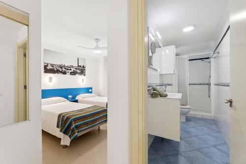 una camera da letto bianca con un letto e un bagno di Apartamento FORESTA 6 a San Bartolomé