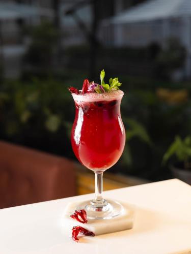 una bebida roja en un vaso sentado en una mesa en Megha Resort & Villas, Dehradun-Where Nature Pampers You, en Dehradun