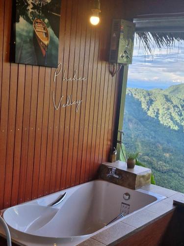 a large bath tub in a room with a window at Phahee valley ผาฮี้วัลเล่ย์ in Ban Ko Doi Tung