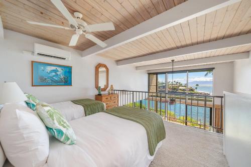 a bedroom with two beds and a balcony at Napili Point C22 · NP C22 Oceanfront Views from 2BD West Maui Co in Lahaina