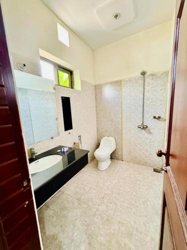 a bathroom with a toilet and a tub and a sink at Hotel Pak Continental Multan in Multan