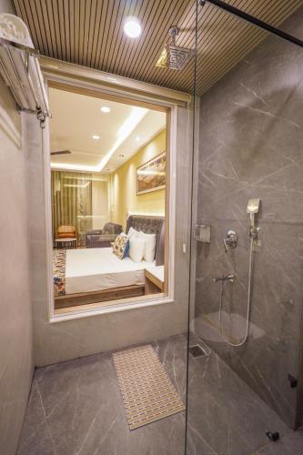 a bedroom with a bed and a shower in a room at Carom Hotel Manali in Manāli