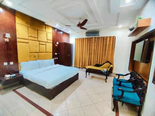 una camera da letto con un letto, un divano e una TV di Hotel Pak Continental Multan a Multan