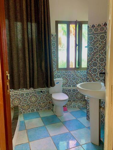 a bathroom with a toilet and a sink at Hotel Complex Europe in Guercif
