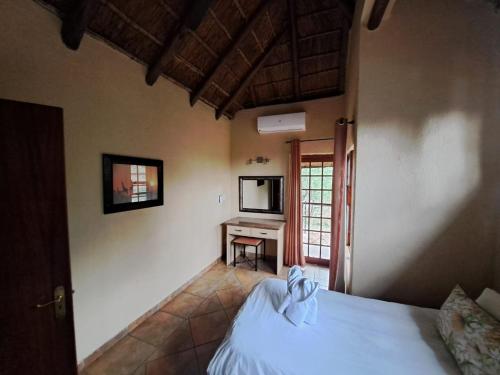 Unit 77 Kubu Mabalingwe nature reserve في وارمباثس: غرفة نوم بها سرير وتلفزيون