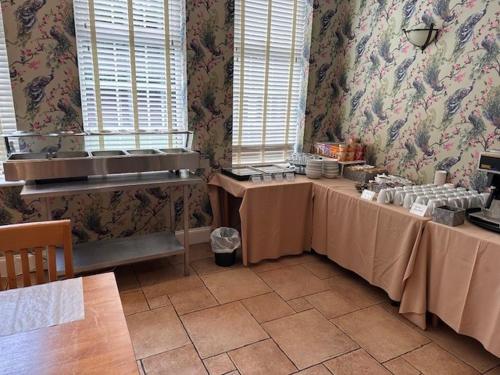 a kitchen with two tables in a room at Deincourt Hotel in Newark upon Trent