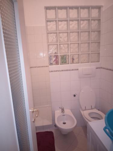 a white bathroom with a toilet and a sink at A un passo dal centro gli orsetti del duomo in Piacenza