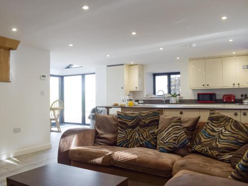 a living room with a couch and a kitchen at Cider Mill in Bullingham