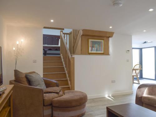 a living room with two chairs and a staircase at Cider Mill in Bullingham