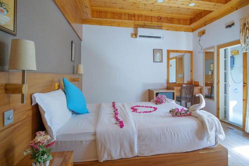 ein Schlafzimmer mit einem Bett mit Blumen darauf in der Unterkunft Fasdheythere Inn Maldives in Kendhoo