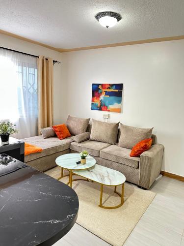 a living room with a couch and a table at Galaxy Suites Meru in Meru