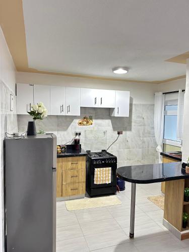a kitchen with a stove and a table in it at Galaxy Suites Meru in Meru