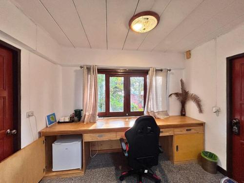 um escritório com uma secretária com uma cadeira e uma janela em Sense Asia em Haad Tian