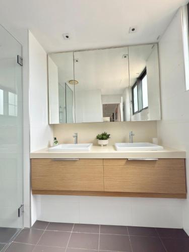 a bathroom with two sinks and a large mirror at The Palms at Waterfront in Darwin