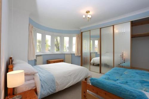 1 Schlafzimmer mit 2 Betten und einem Spiegel in der Unterkunft Bournemouth Holiday Home in Southbourne