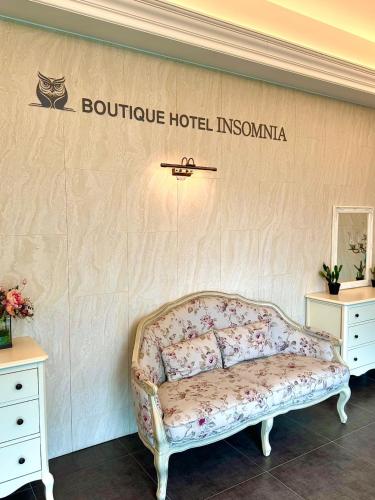 a bed in a room with a sign on the wall at INSOMNIA Hotel in Hyomoktong-Ilgu
