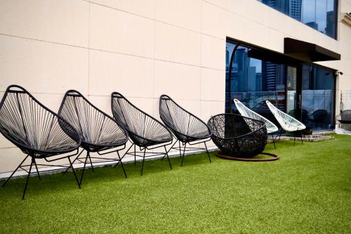 a group of chairs sitting next to a building at INSOMNIA Hotel in Hyomoktong-Ilgu