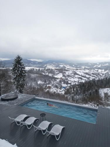 a swimming pool with two lounge chairs at Rest Hub in Slavske