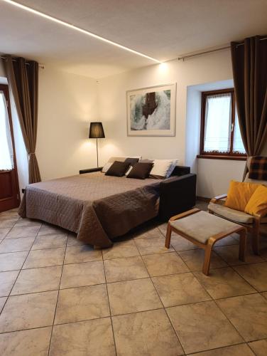 a bedroom with a large bed and a couch at Residenza dentro le mura - 5 min walk to Bernina Express in Tirano