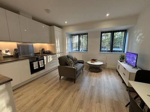 Una sala de estar con un sofá y una cocina. en Cozy Studio in Solihull with Parking - NEC or Airport, en Solihull