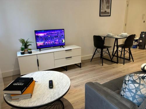 Una sala de estar con un televisor y una mesa. en Cozy Studio in Solihull with Parking - NEC or Airport, en Solihull