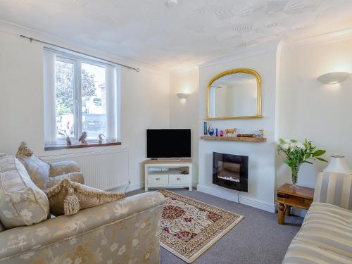 a living room with a couch and a television at Ravensmere Villa in Beccles