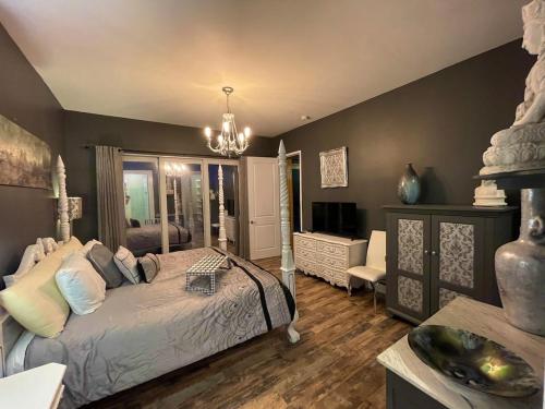 ein Schlafzimmer mit einem Bett, einem TV und einem Sofa in der Unterkunft The Beach House Zen Place Luxury Amazing Views in Naples