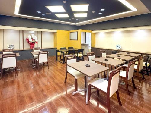 a dining room with tables and chairs and flowers at 下関大坂屋ホテル in Shimonoseki