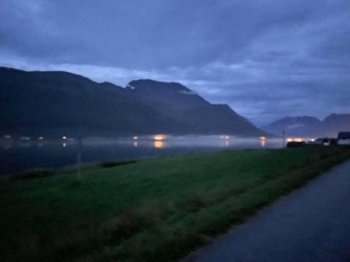 a foggy field with a road and mountains in the background at Paradis in Norway in Nord-Lenangen