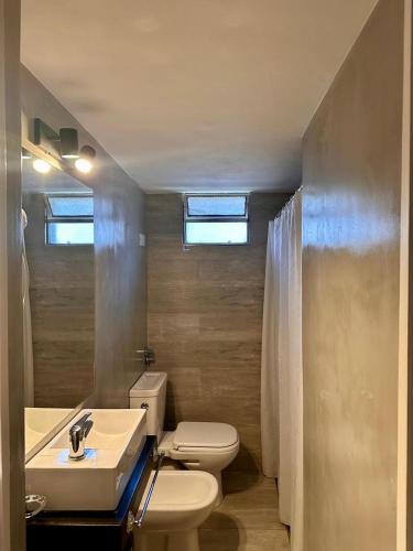 a bathroom with a white toilet and a sink at Apart Hosteria Plaza- La Cumbre in La Cumbre