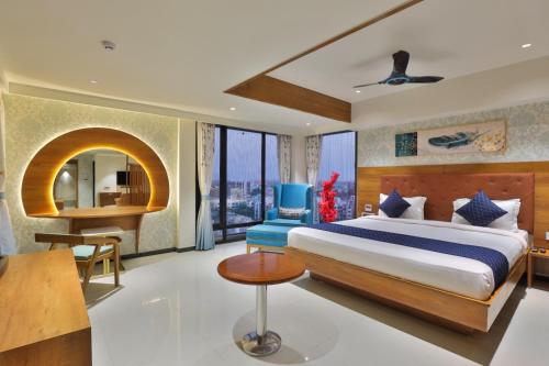 a bedroom with a bed and a desk and a chair at Empyrean Resort in Gandhinagar