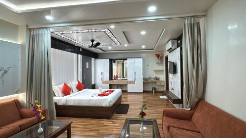 a hotel room with a bed and a living room at Rooftop Sea View Marine Drive Road Duren- Beach-Resort # Jagannath Temple #Fully Air Condition with All Premium Rooms With Attached #Balcony Free Wifi & Lift Facilities- Top Rated Hotel in Puri