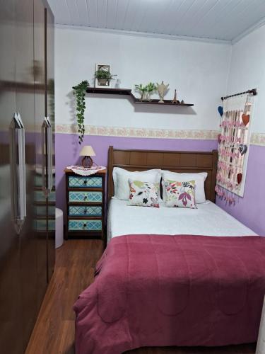 a bedroom with a bed with a purple blanket at Dexa Hospedagem in Ouro Preto
