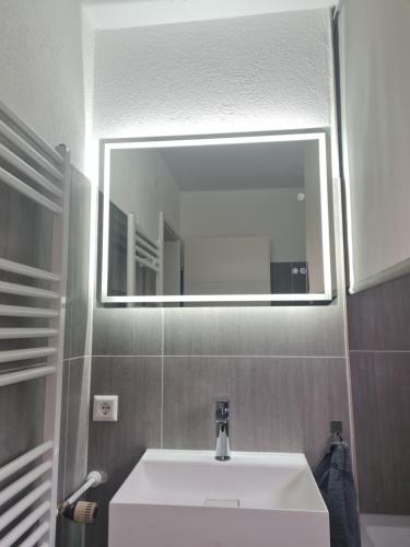 Un baño con un lavabo blanco y un espejo. en Zimmer-Leutkirch, en Leutkirch im Allgäu