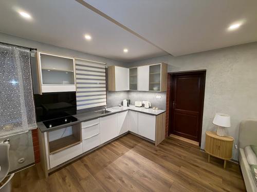 a kitchen with white cabinets and a black counter top at Apartmán v Dráze in Zásada