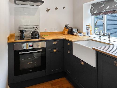 eine Küche mit Spüle und Herd oberen Backofen in der Unterkunft The Butterchurn - Uk50805 in Cratfield