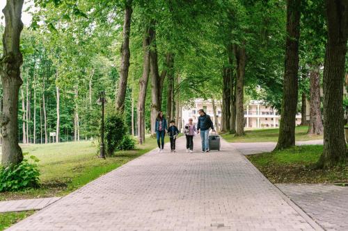 a group of people walking down a sidewalk in a park at PÚŠŤ rekreačné stredisko in Prievidza
