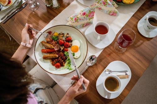 eine Person, die einen Teller Essen auf einem Tisch isst in der Unterkunft PÚŠŤ rekreačné stredisko in Prievidza