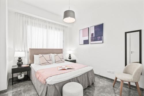 リマソールにあるNoir Luxury Residences by Nomadsの白いベッドルーム(大型ベッド1台、椅子付)