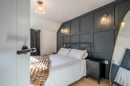 een slaapkamer met een bed en een zwarte muur bij Pink Cottage in Leiston