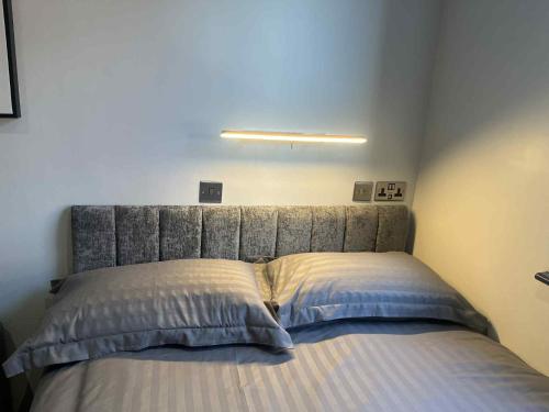 a bed with a gray headboard in a bedroom at The Stadium Hotel Anfield in Liverpool