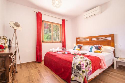 een slaapkamer met een groot bed met rode gordijnen bij Villa Sabine - PlusHolidays in Calpe